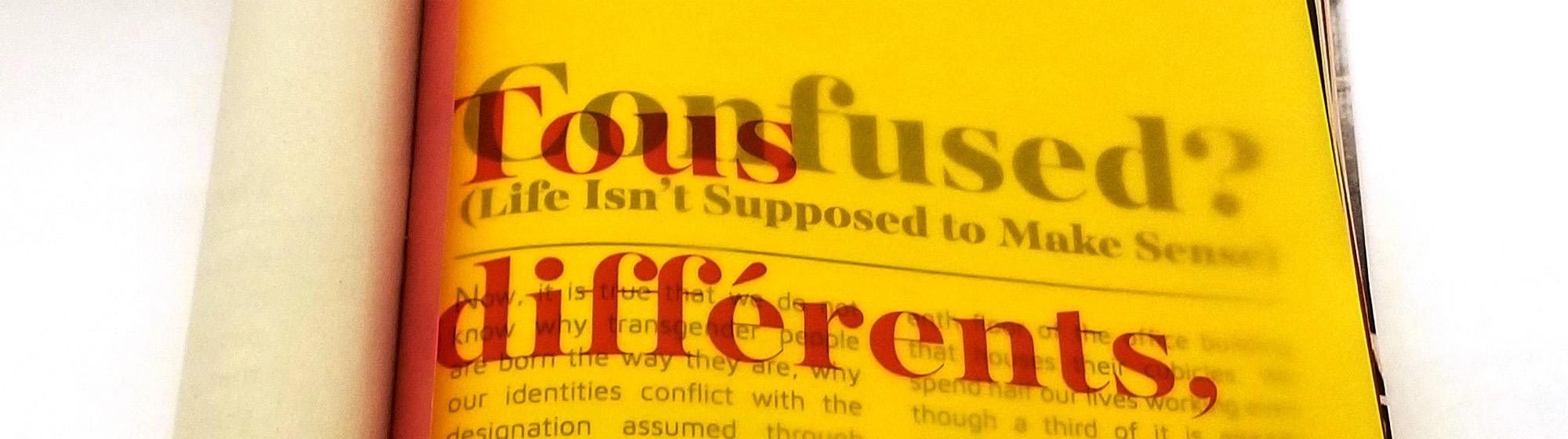 close up view of yellow transparent paper with vibrant red text that reads “Tous différents,”
